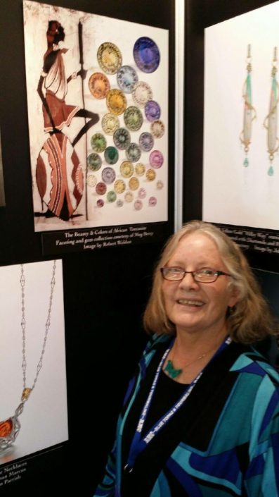 Meg Berry with poster of her cut tanzanites. Photo by Robert Weldon